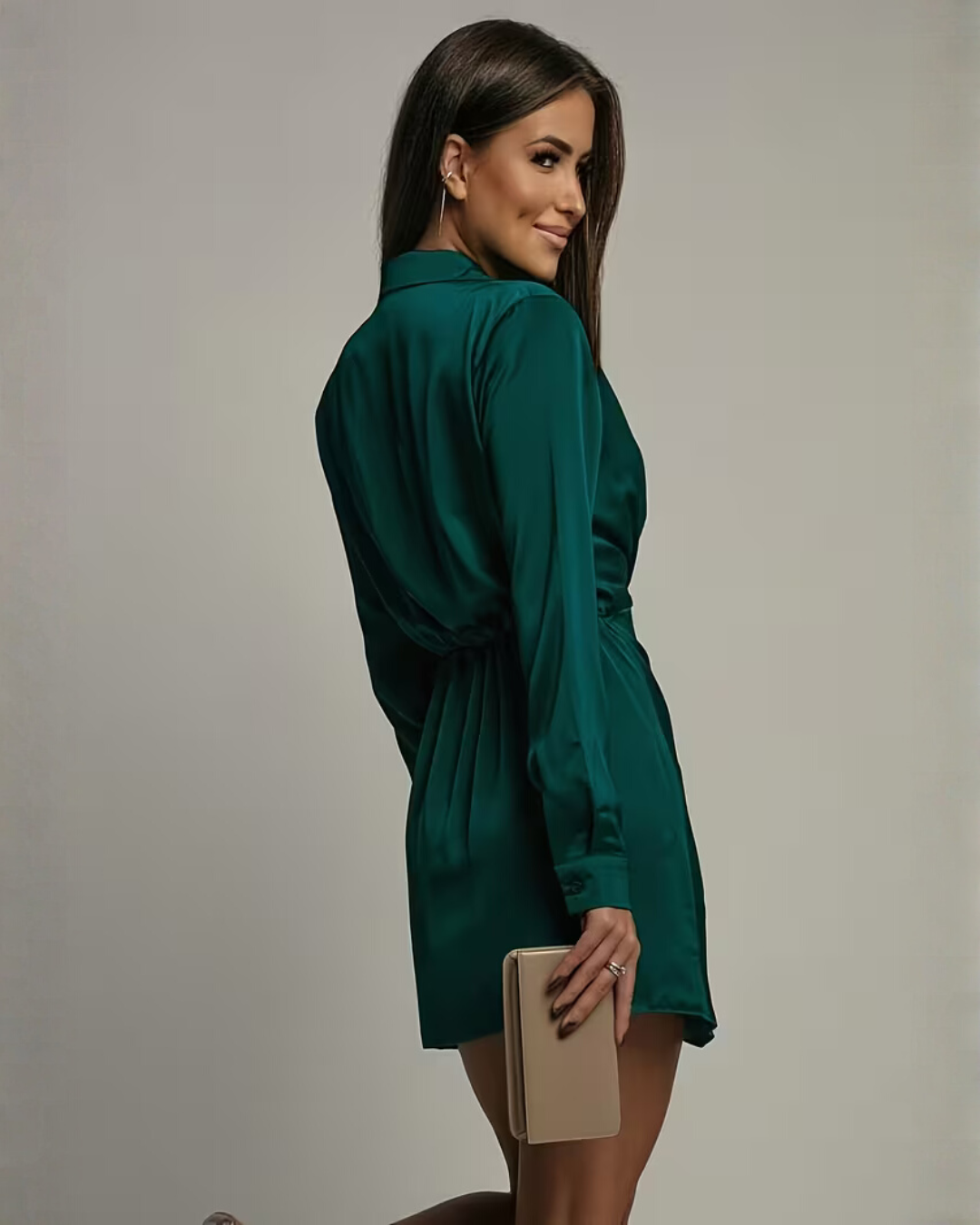 Woman posing in a satin-look mini dress with collared neckline on a plain background.
