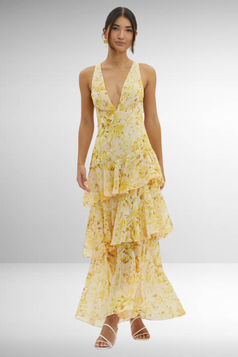 Flowing hem detail floral dress on model plain background