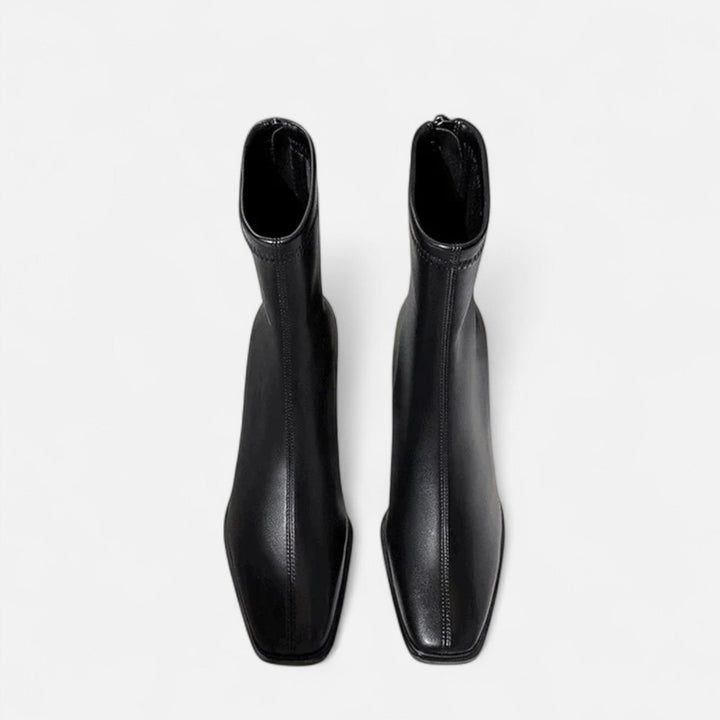 Square toe boots with a sleek matte look on a plain background.
