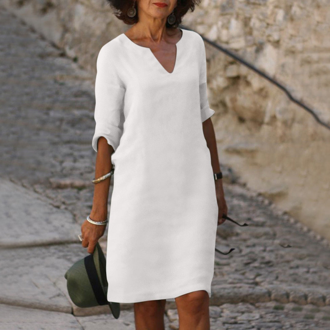 Woman model posing in a relaxed shift midi dress for everyday outings on a clean background.