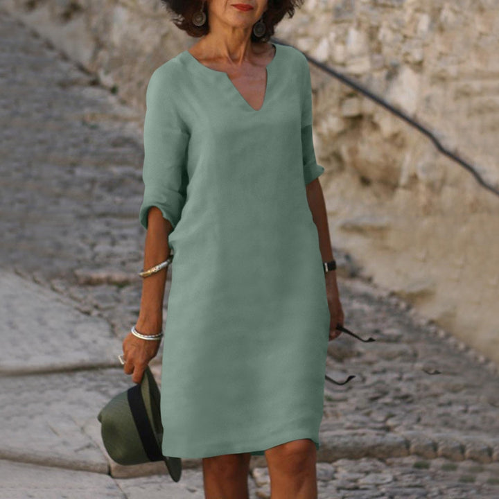 Woman model wearing a casual relaxed midi dress with an easy fit on a plain background.