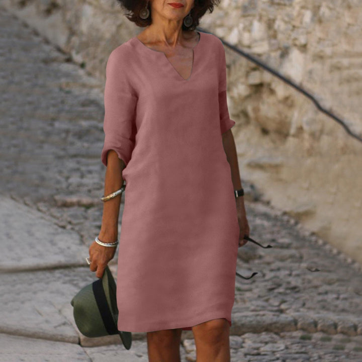 Woman model in a relaxed V-neck midi dress with 3/4 sleeves against a clean background.