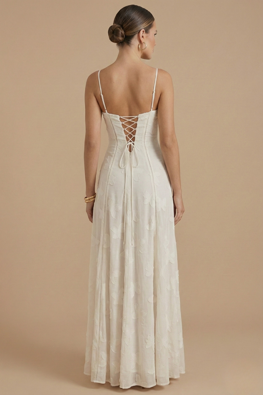  Woman in a flowing floral maxi dress with a fitted bodice on a plain background.