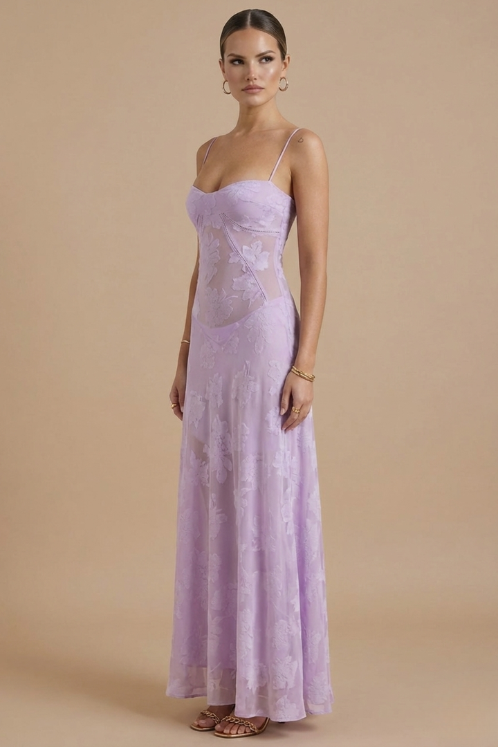  Model in a formal floral maxi dress with soft flowing movement on a plain bac