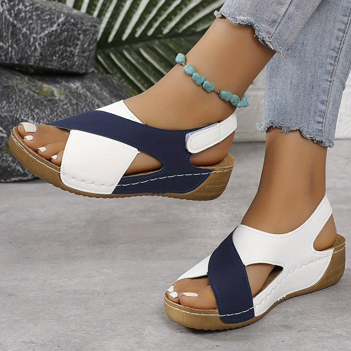 Woman wearing hiking sandals on a plain background