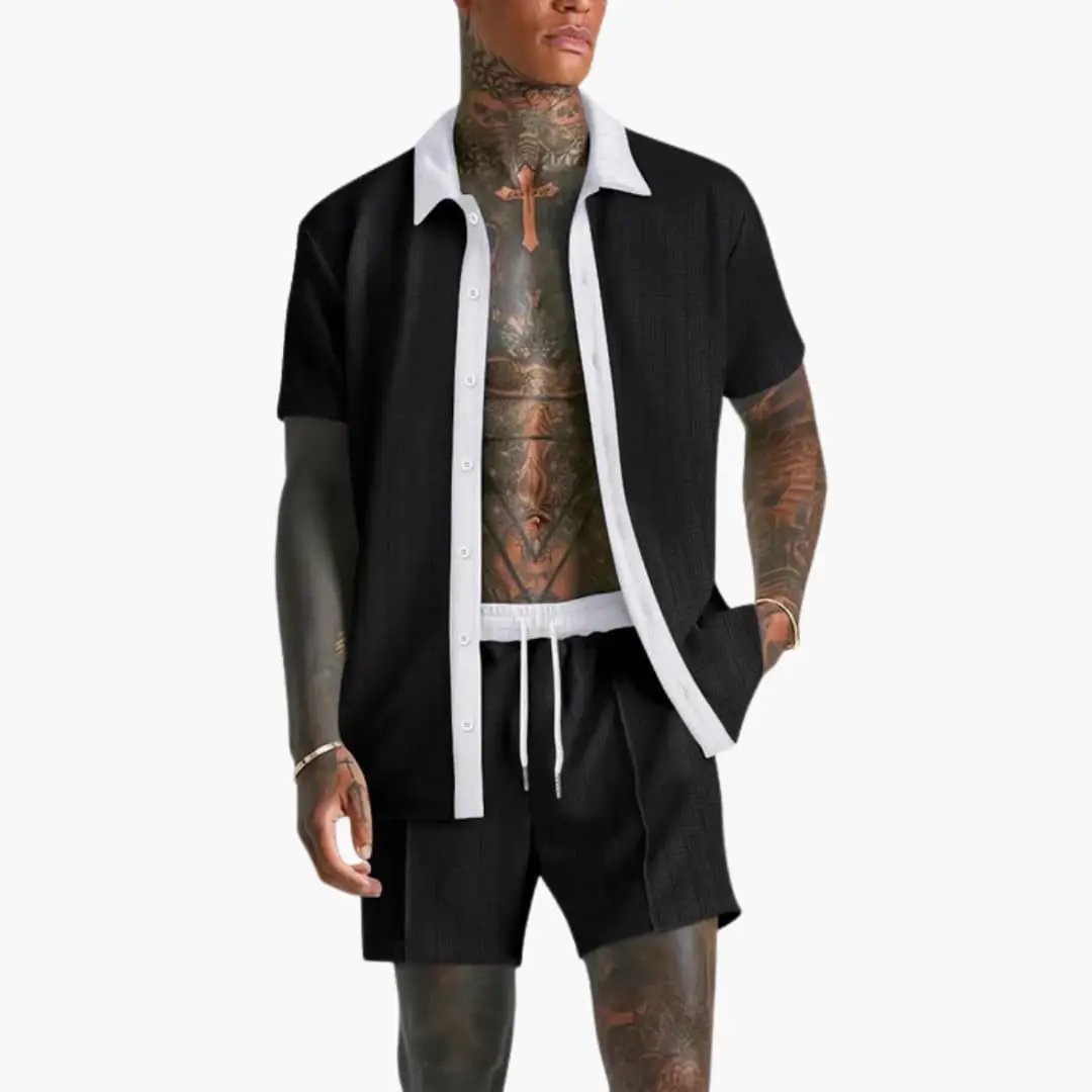  Model in a coordinated men’s short sleeve shirt and drawstring shorts set on a plain background.
