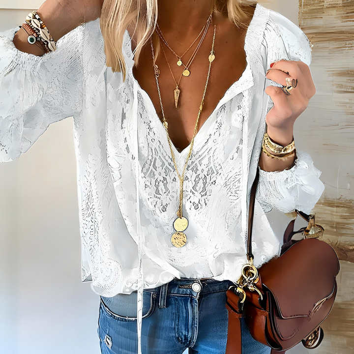 Female model in a flowing boho V-neck blouse on a clean background.