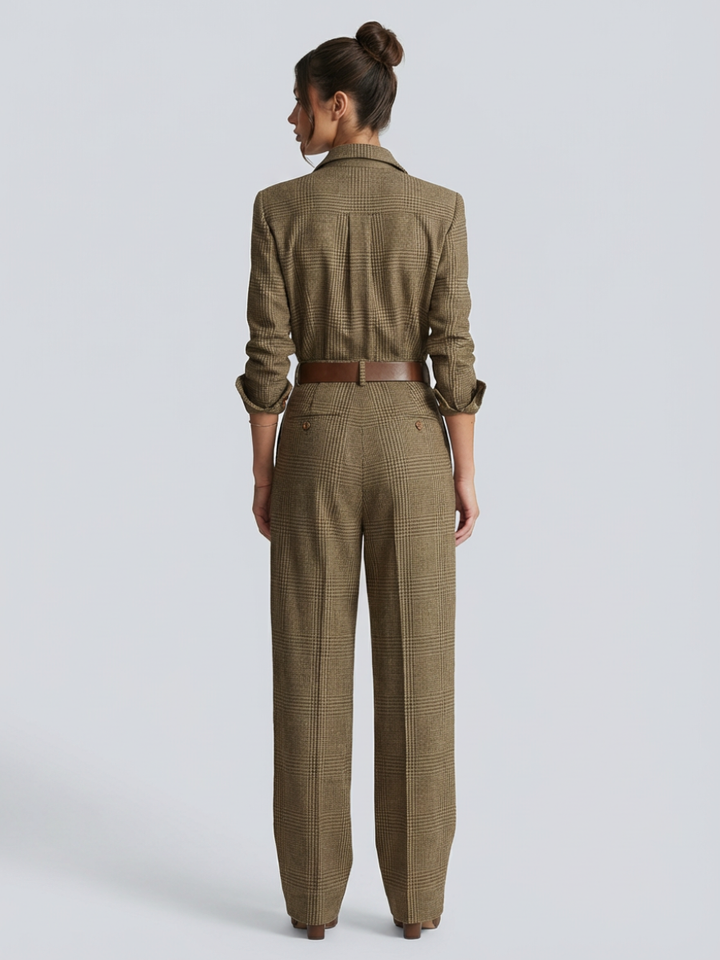 Woman in a tailored beige check jumpsuit with round neckline against a plain background.