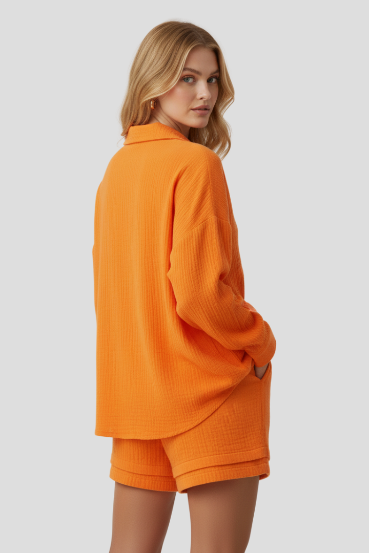 Female model wearing casual textured co-ord set against plain gray background and in back angle view