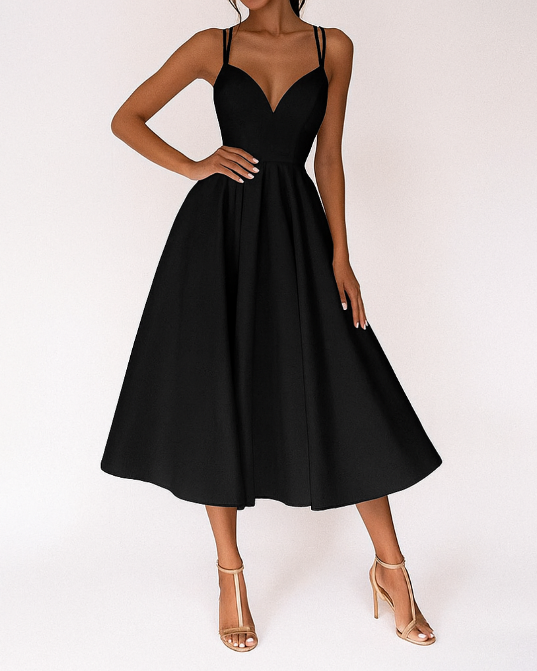 Woman wearing a strappy occasion dress with a midi-length silhouette on a plain background.