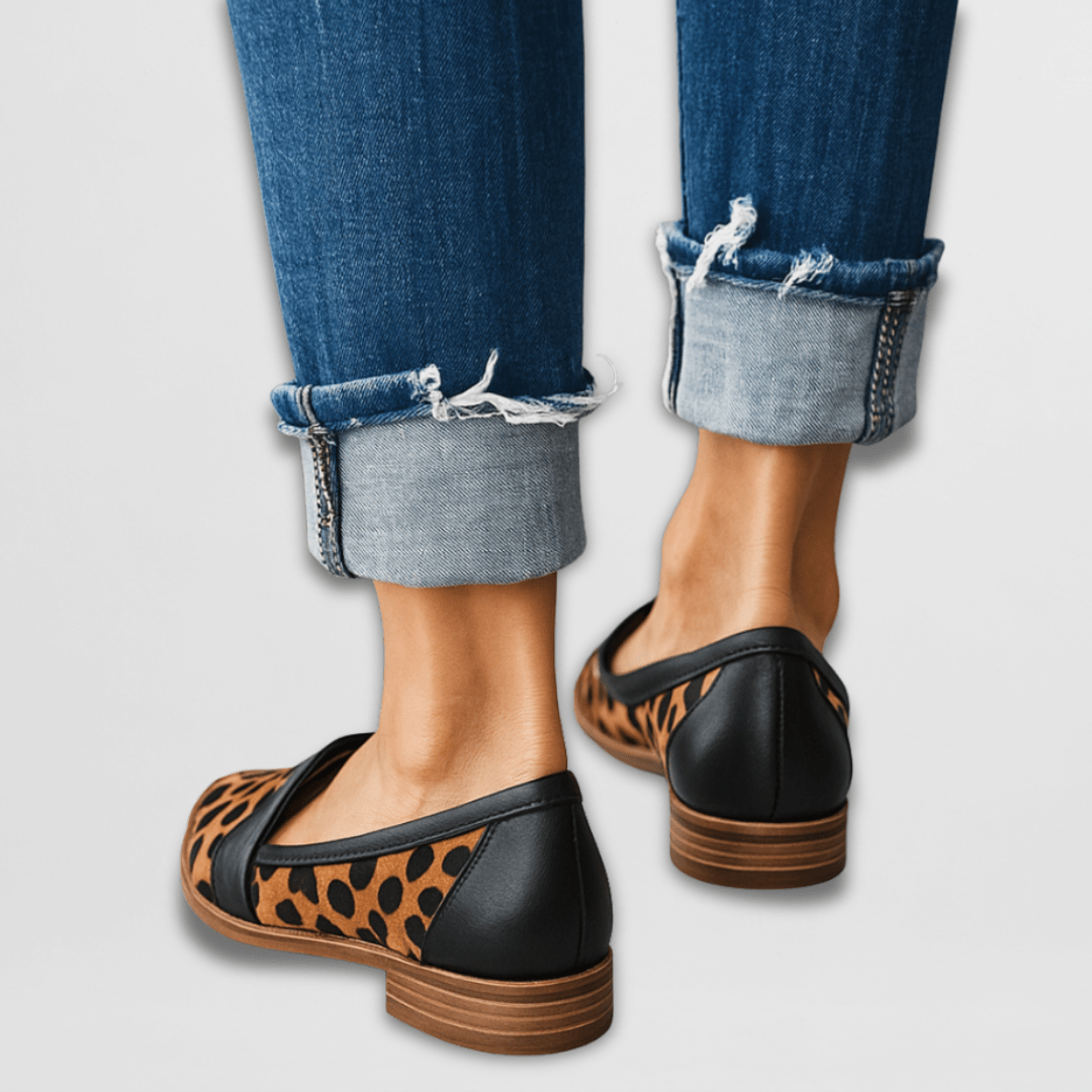  Female wearing classic loafers with a polished look on a plain background.