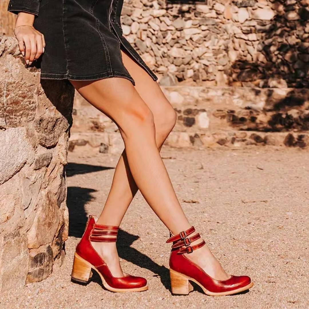  Female showcasing contemporary sandals against a plain background.
