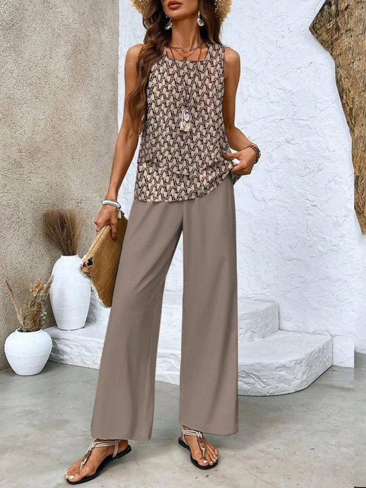  Female model showcasing a relaxed two-piece outfit with wide-leg trousers on a plain background.