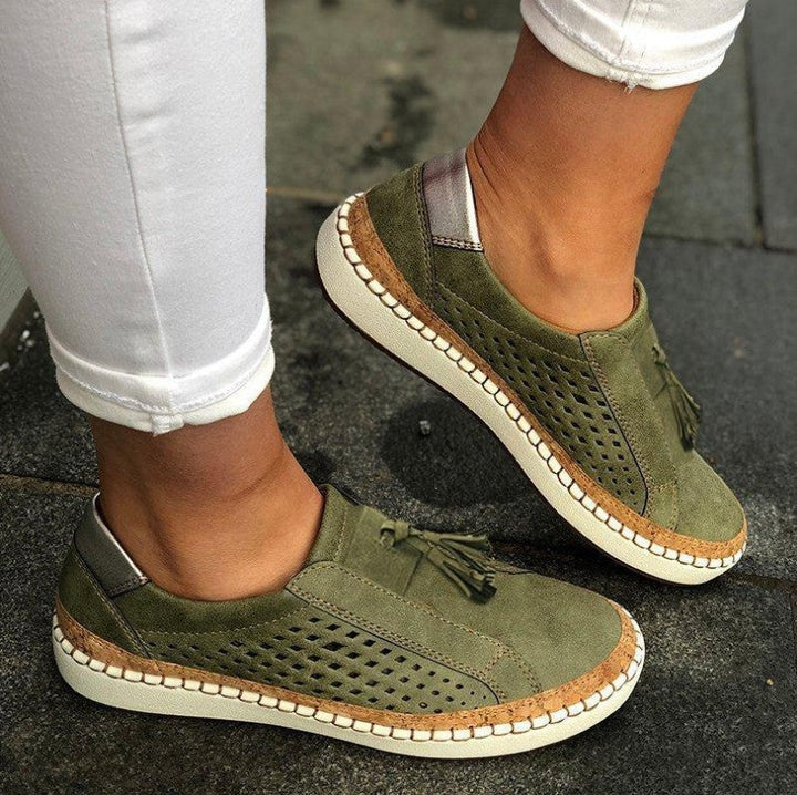 Female model showing casual slip-on slippers on a plain background.