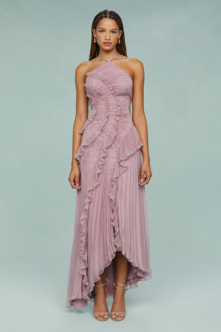 Woman styled in a graceful dress for formal occasions on a plain background.