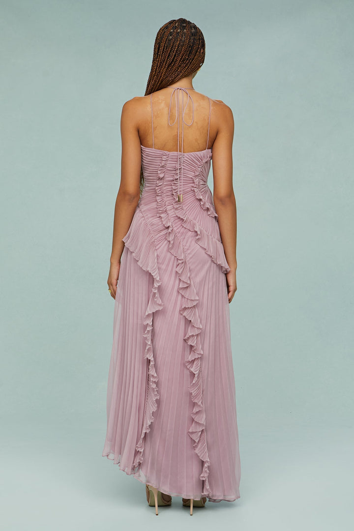 Model wearing a flowing dress with a refined neckline on a plain background, back view angle
