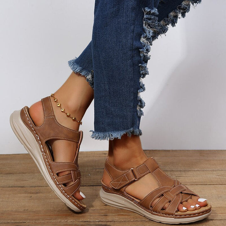 Angled side sandals on plain background showing foot model only
