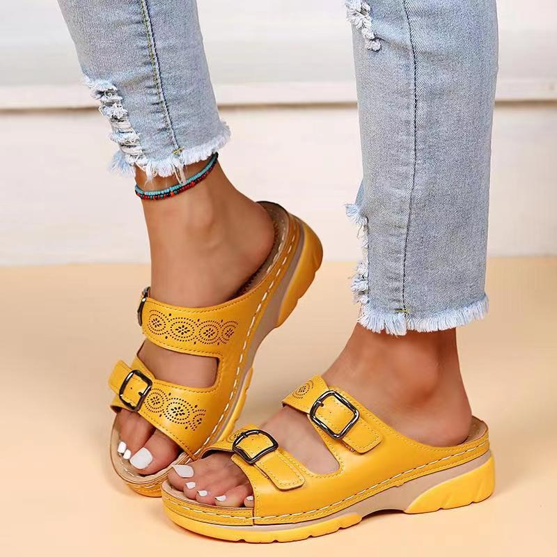 Close-up buckle straps detail on foot model beige background
