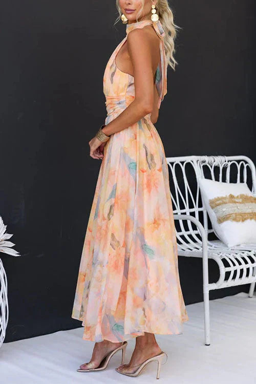 Woman model posing in a sleeveless floral halter dress on a clean background, side way