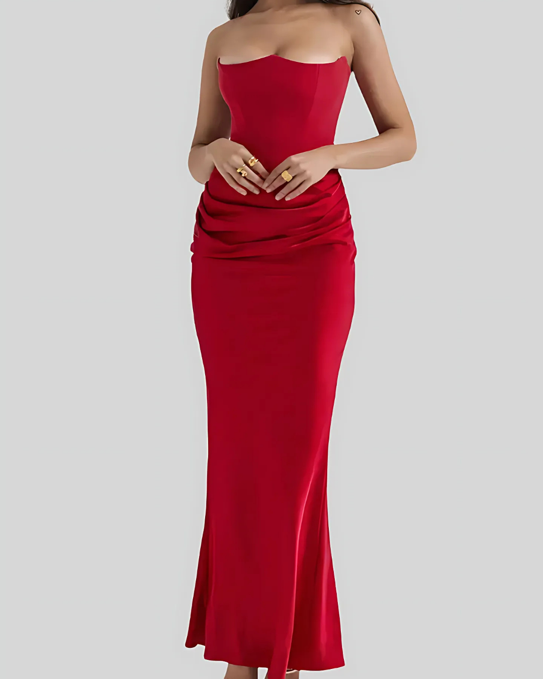Model posing with hands down showing dress structure plain background