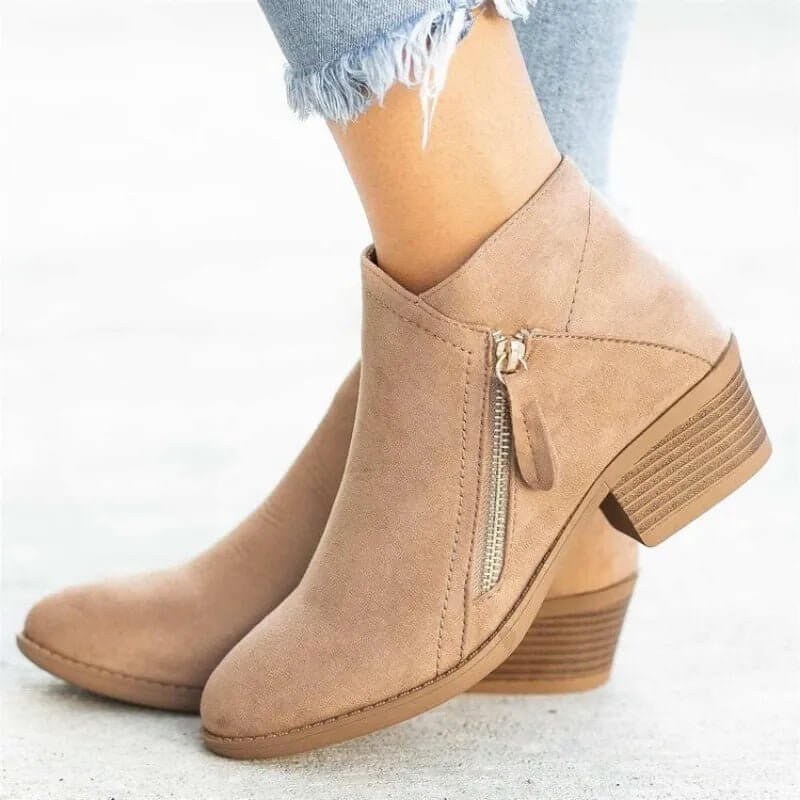 Tan ankle boots with a zipper on a light background