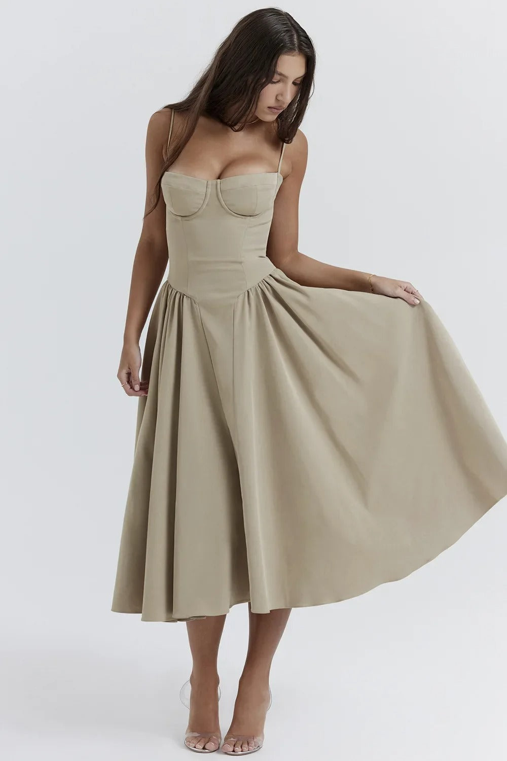 Woman in an elegant flowy outfit against a plain background