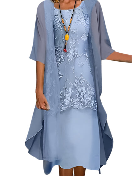 Woman wearing layered midi dress front view on plain gray background.