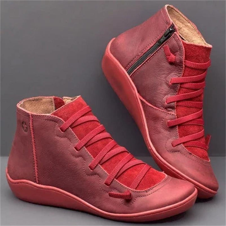 Red high-top sneakers with laces on a gray background