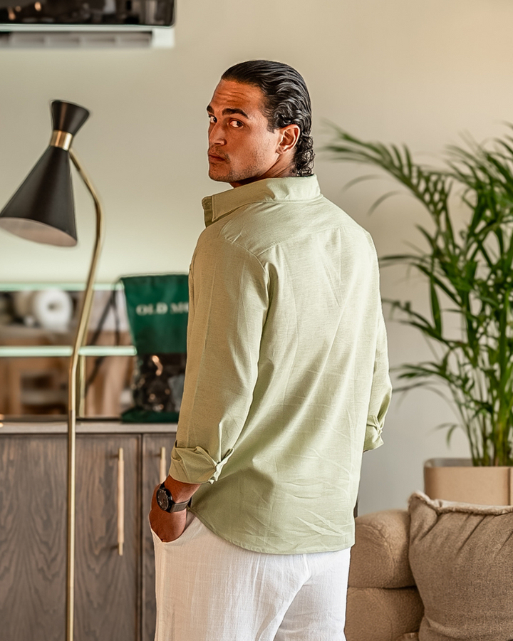  Male model wearing an everyday button down shirt on a plain background.