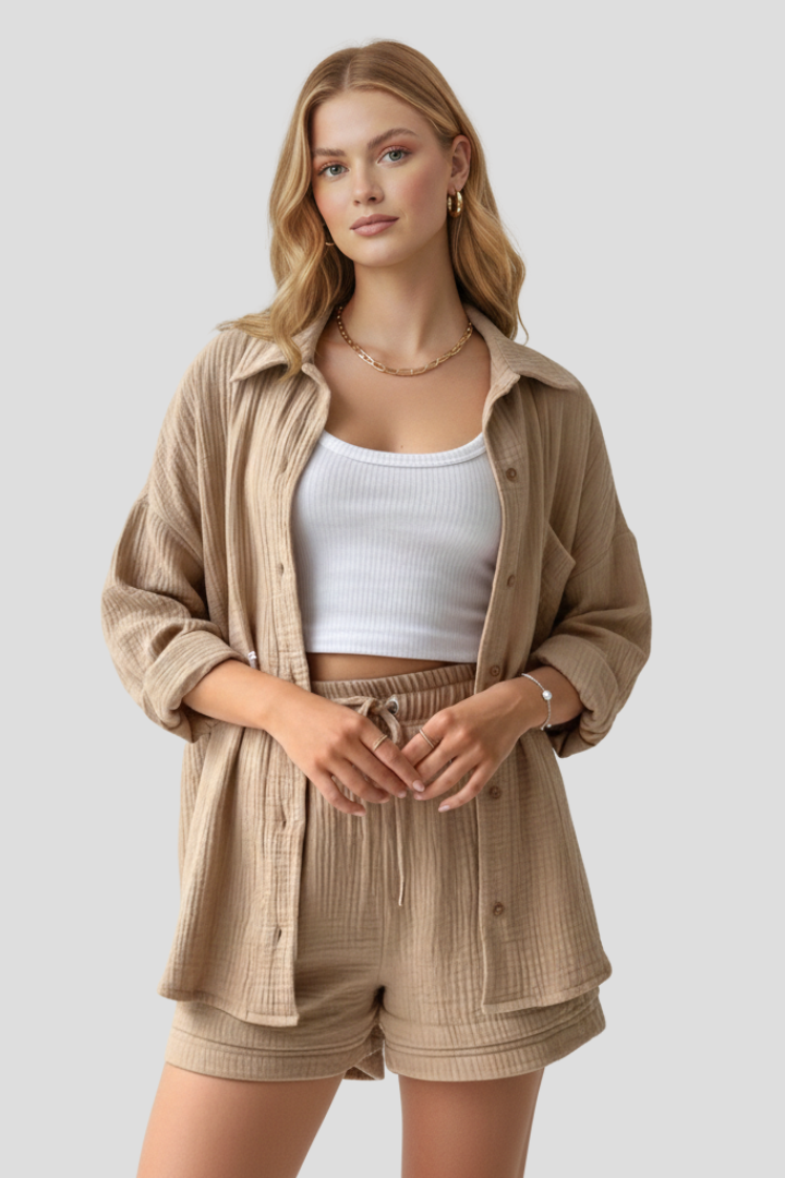 Woman wearing button-front khaki blouse and shorts set, plain gray background.