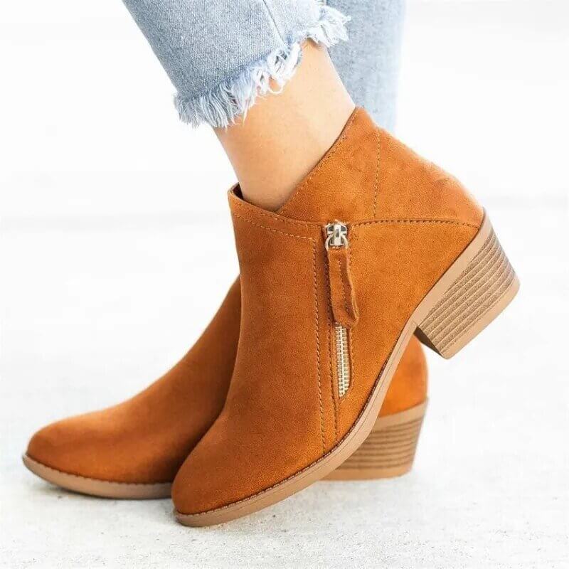 Brown ankle boots with a zipper on a light background