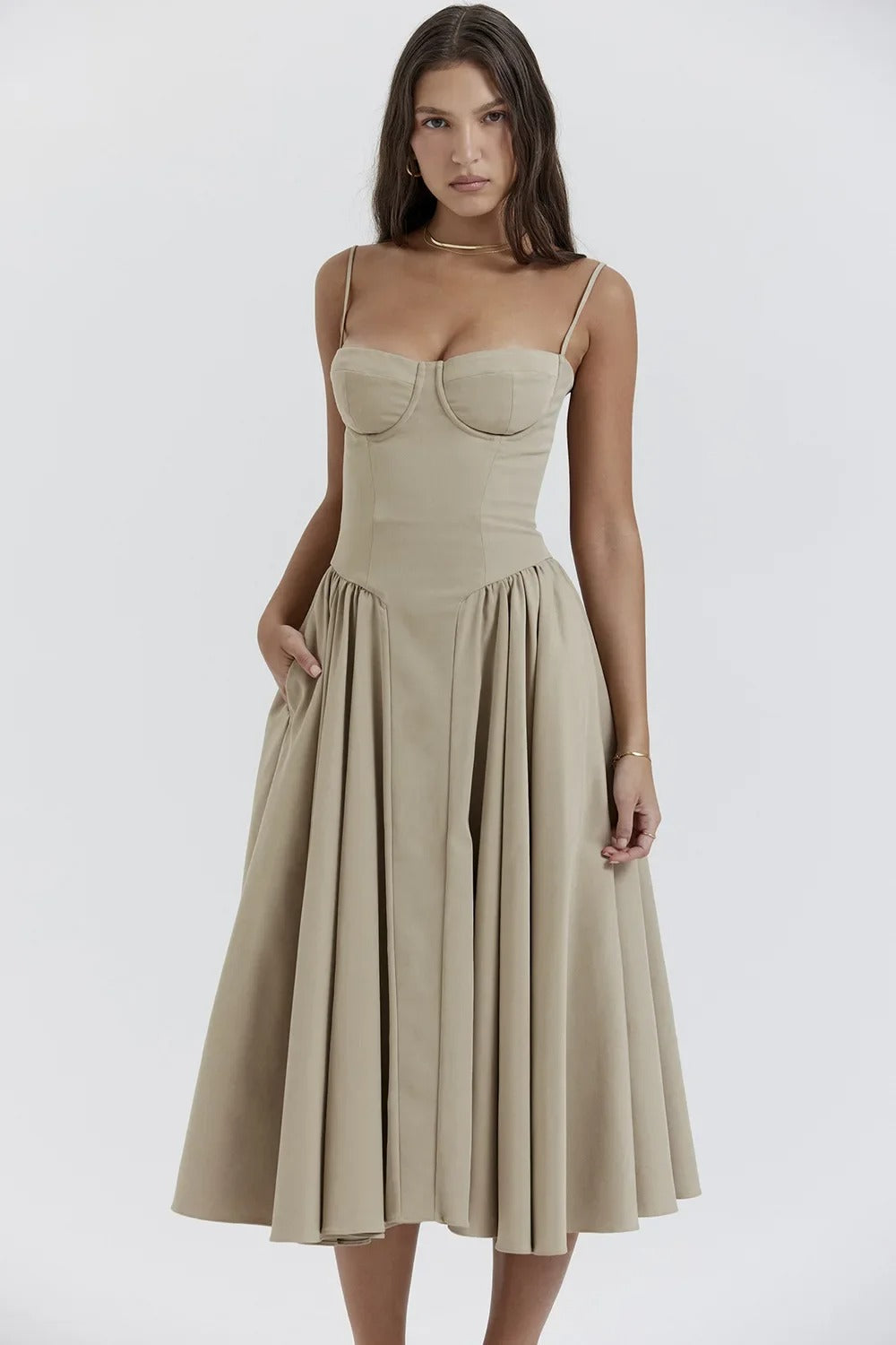 Female wearing a lightweight sleeveless fashion dress on a plain background