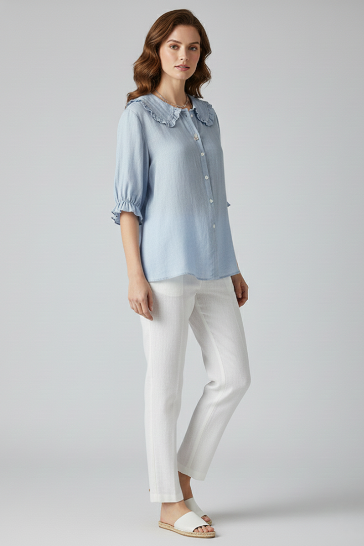Delicate frill neck shirt on grey backdrop side view