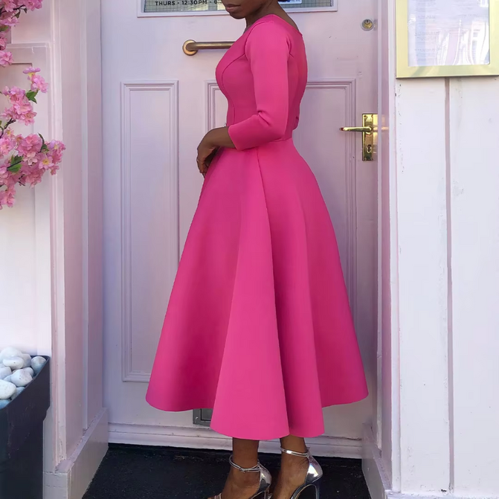 Model in stylish occasion pink dress with door backdrop setting.