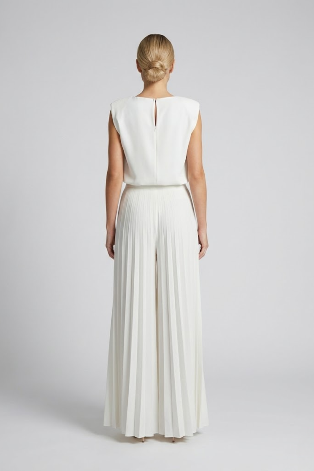 Woman showcasing a chic coordinated set with relaxed styling on a plain background.