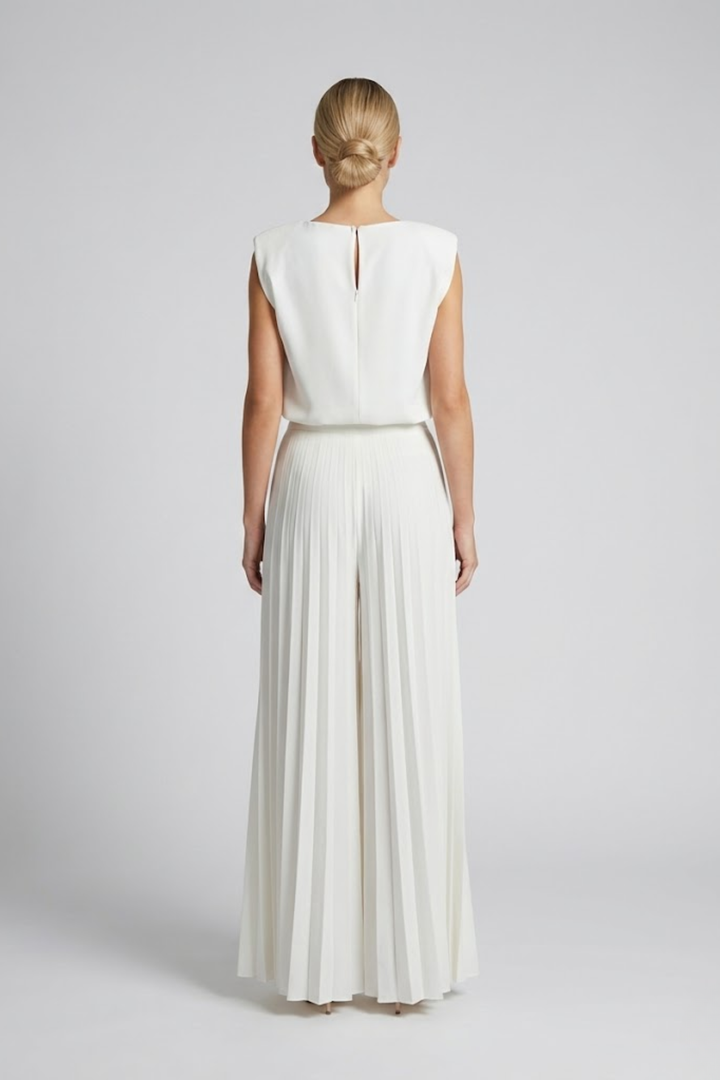 Woman showcasing a chic coordinated set with relaxed styling on a plain background.