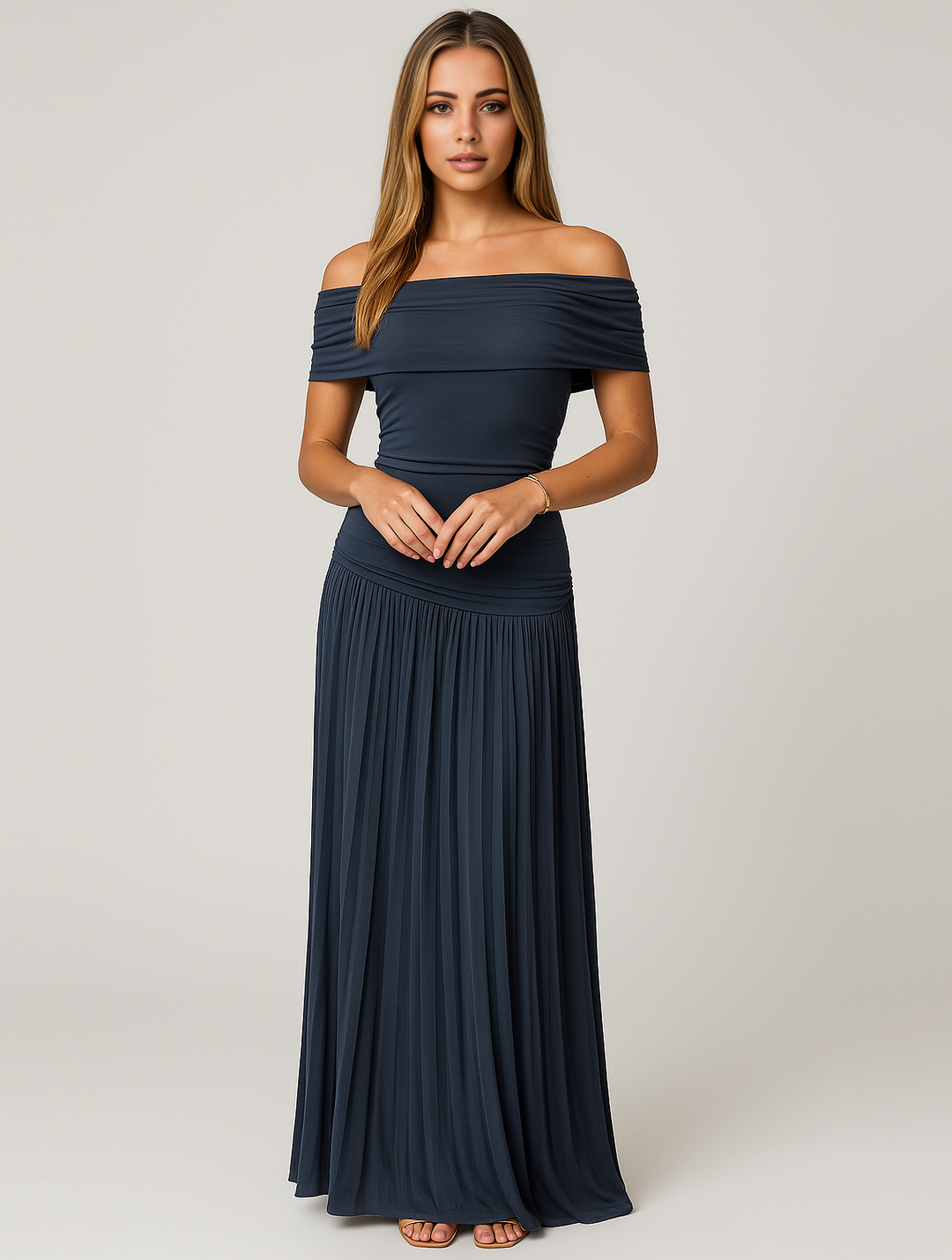 Woman in formal pleated dress with soft movement, gray background.