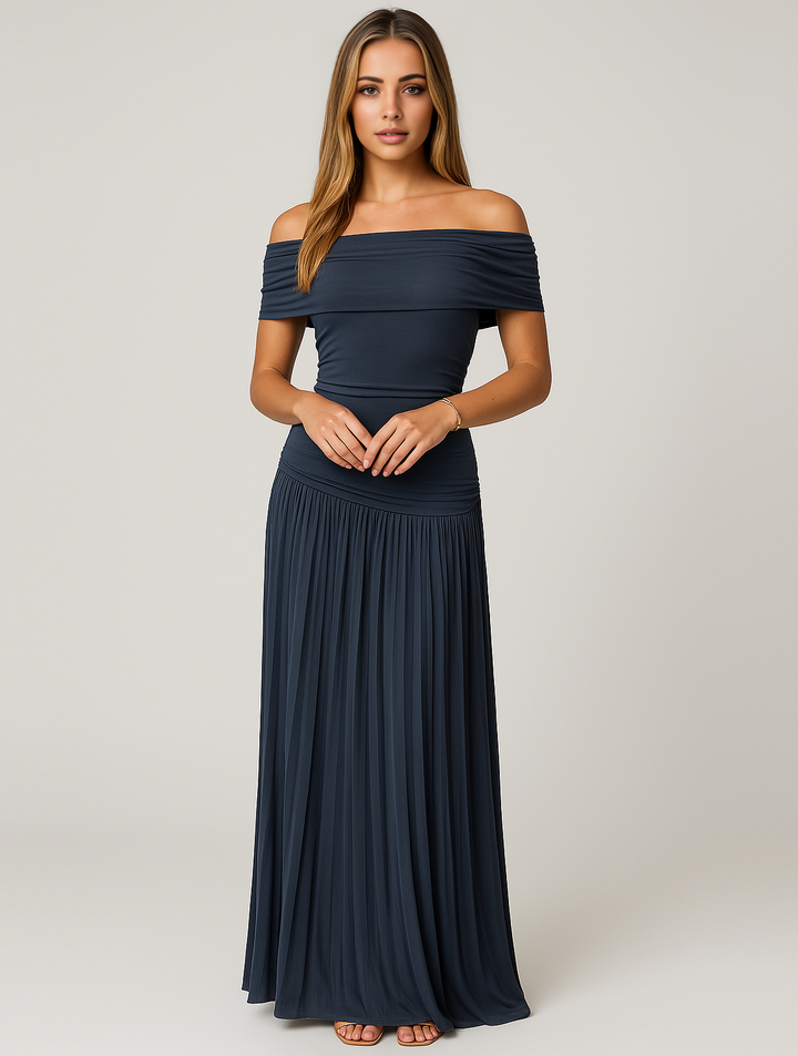 Woman in formal pleated dress with soft movement, gray background.