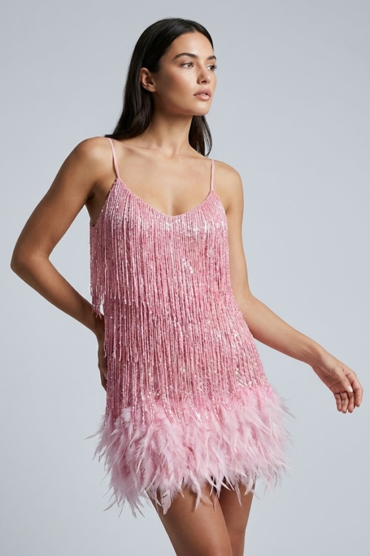 Female model wearing a white evening mini dress with textured fringe on a plain background.