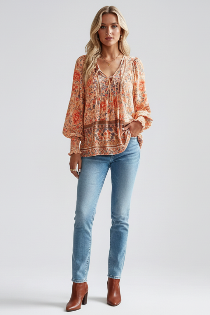 Model in flowy long sleeve top with detailed floral print with jeans and boots