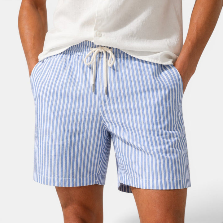 Male model wearing striped shorts against a plain background.