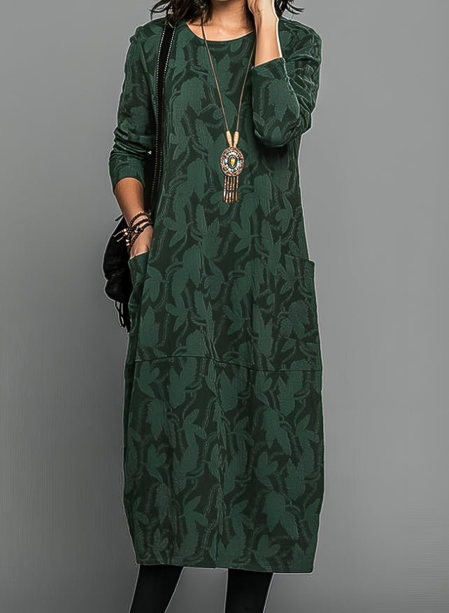Woman wearing printed midi dress front view on gray plain background.