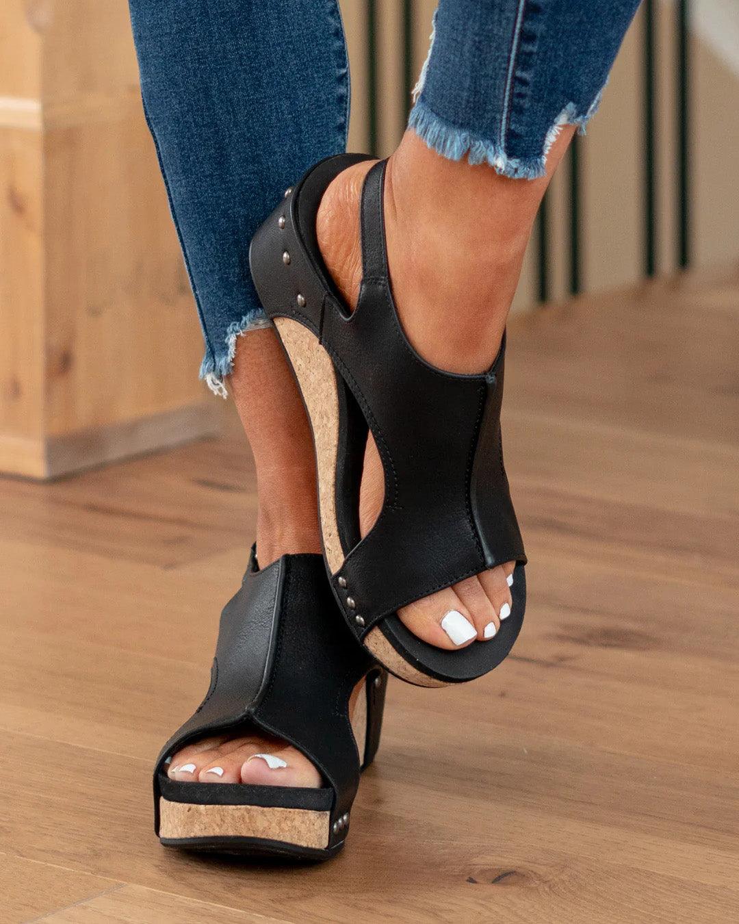 Front close up foot in hiking black sandals on brown floor