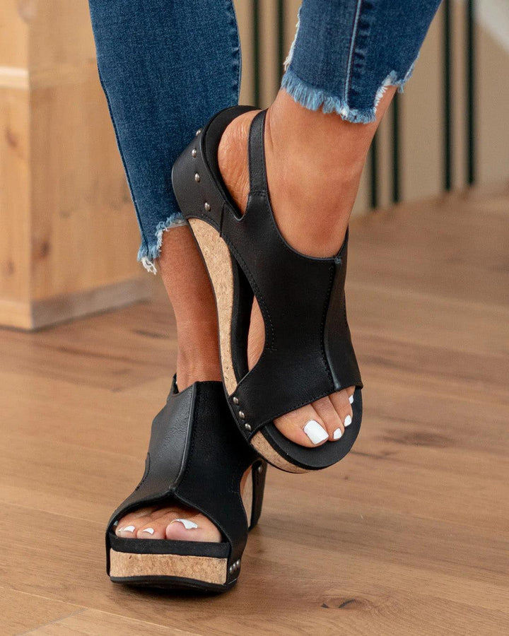 Front close up foot in hiking black sandals on brown floor