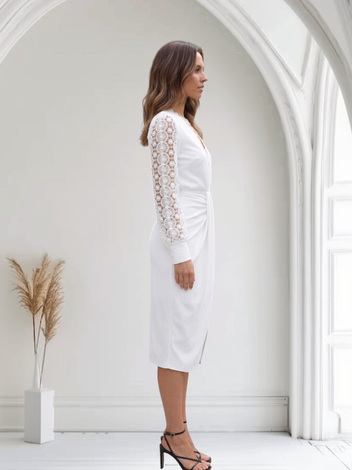 Model in a fitted midi dress with V-neck and lace sleeves against a plain background.