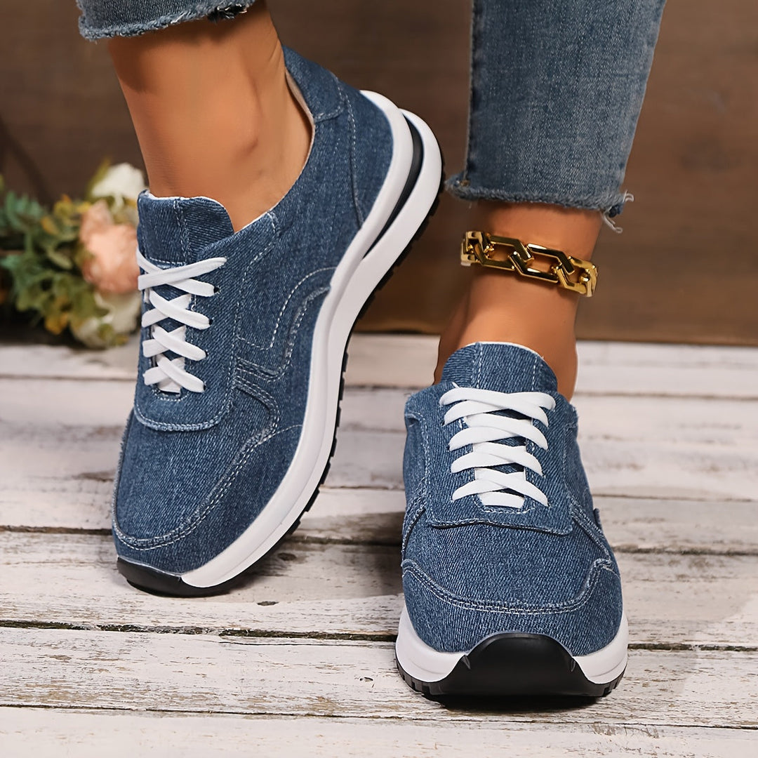 Low top denim sneakers on white wooden floor