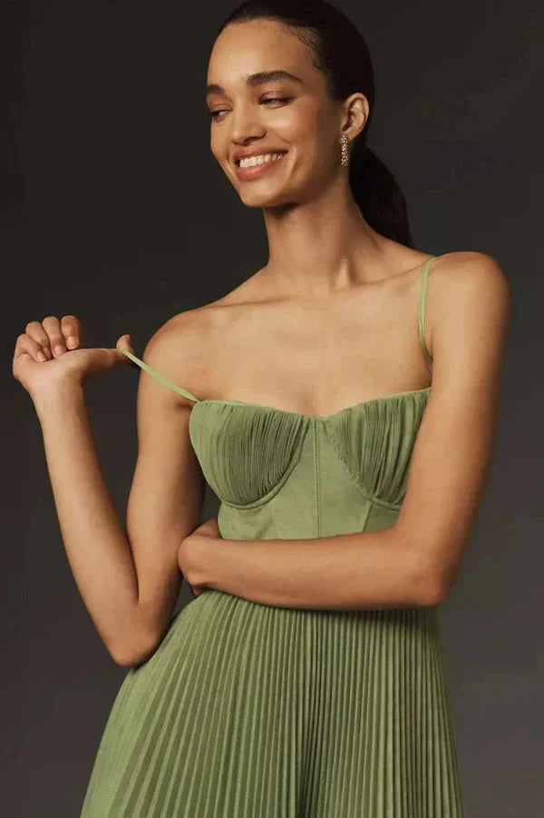 Model in a chic spaghetti strap pleated midi dress with a clean background.