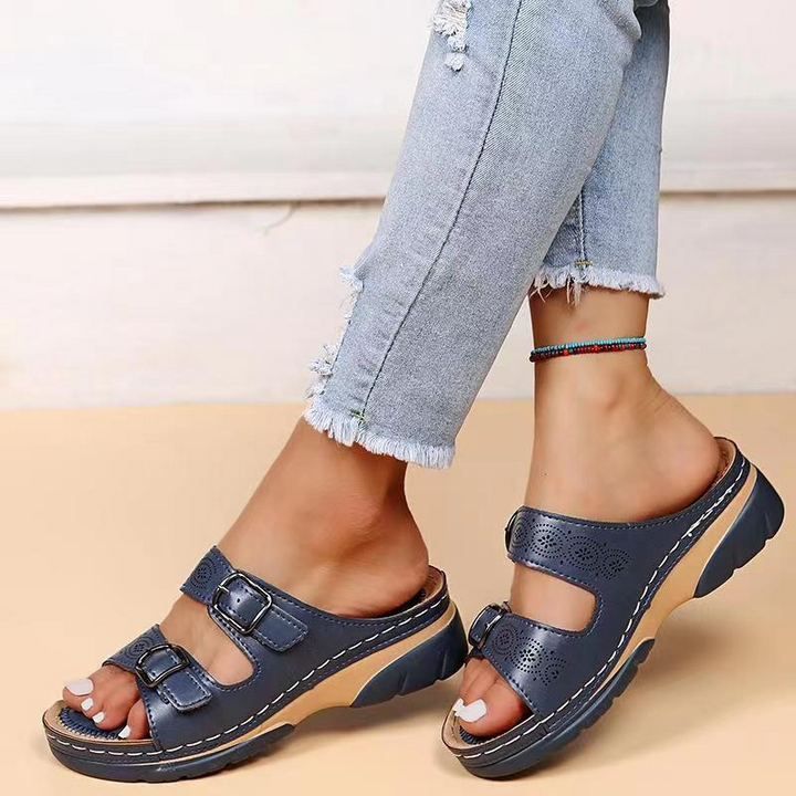 Front view of open-toe sandals on beige background foot model