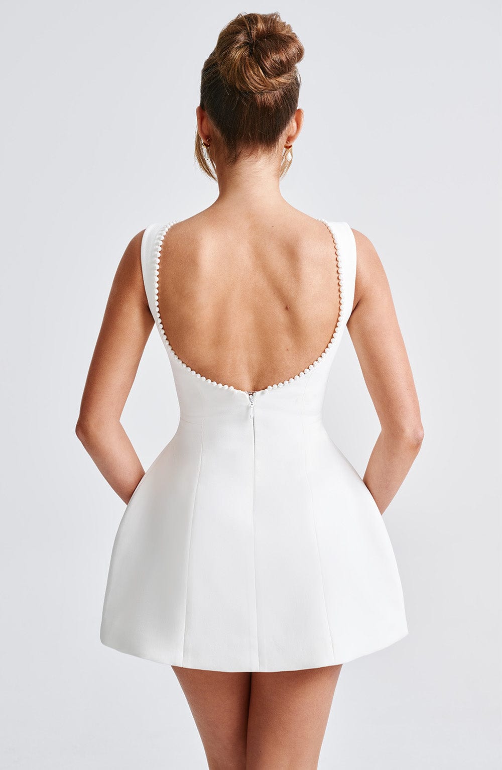 Woman showcasing a fitted mini dress suitable for receptions and celebrations.
