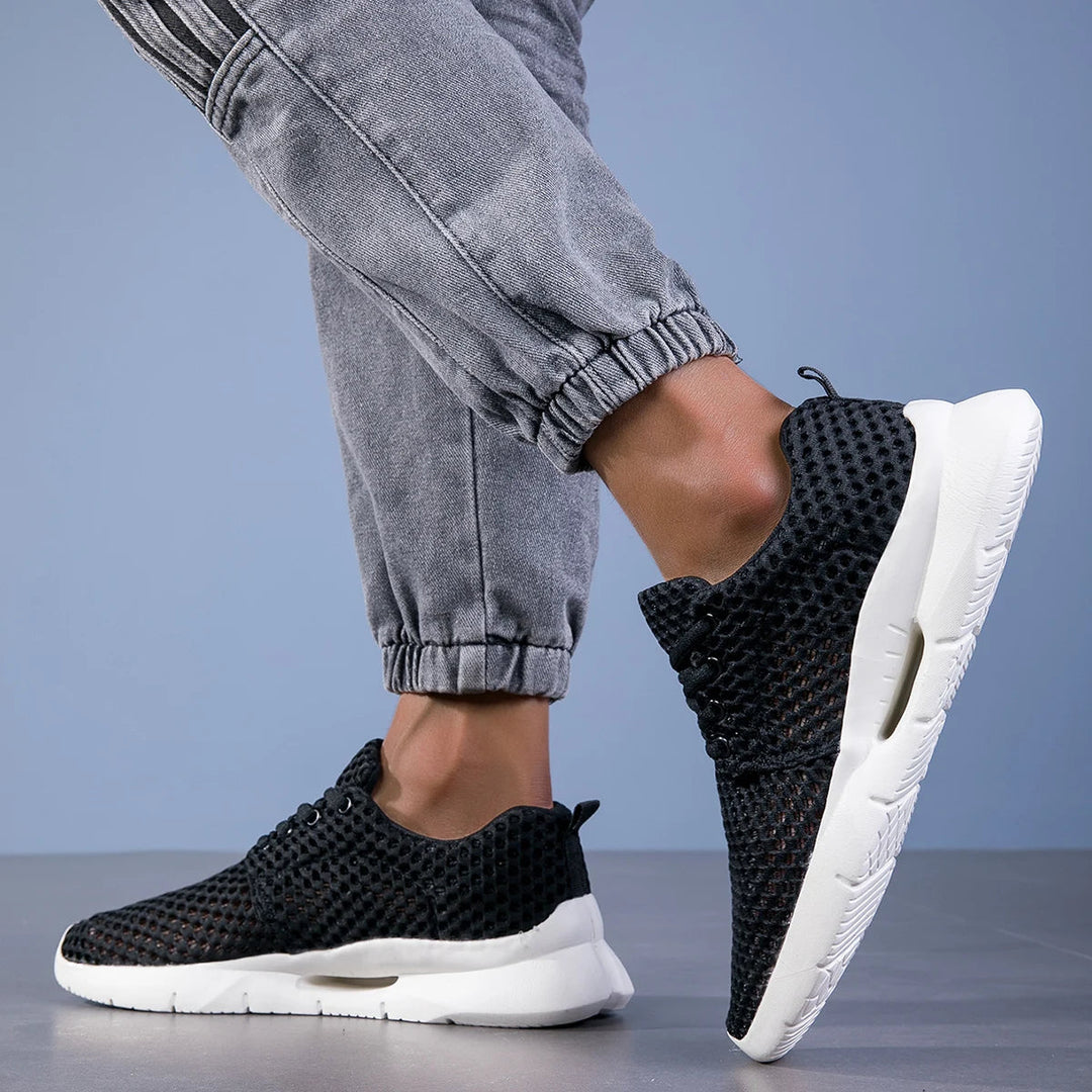 Black mesh lace-up sneakers in indoor setting